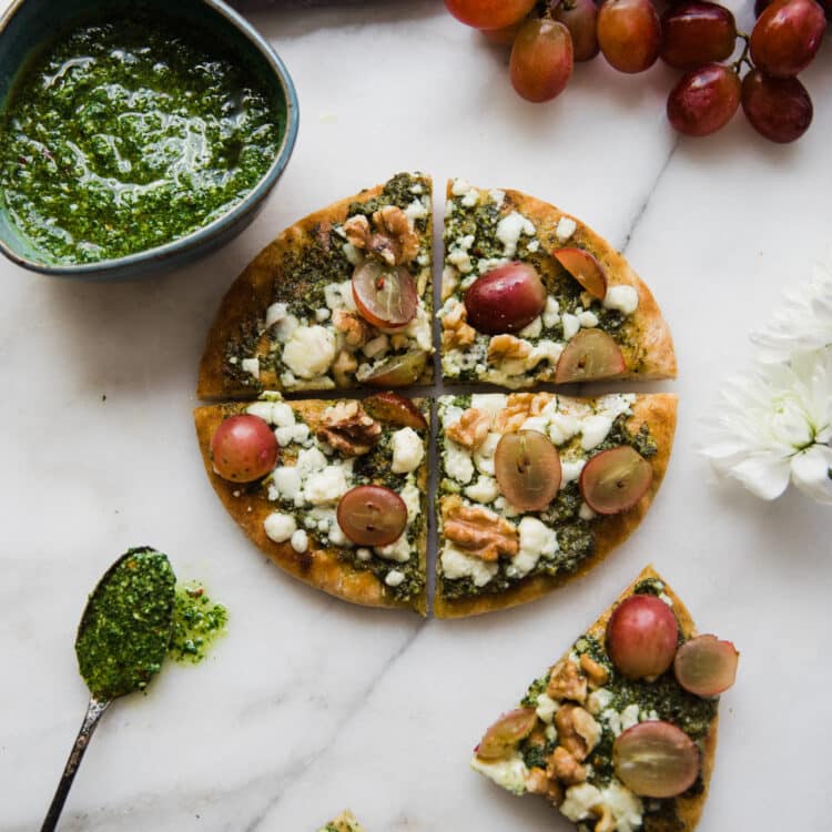 pita pizza made on pita bread with kale pesto, walnuts and red grapes