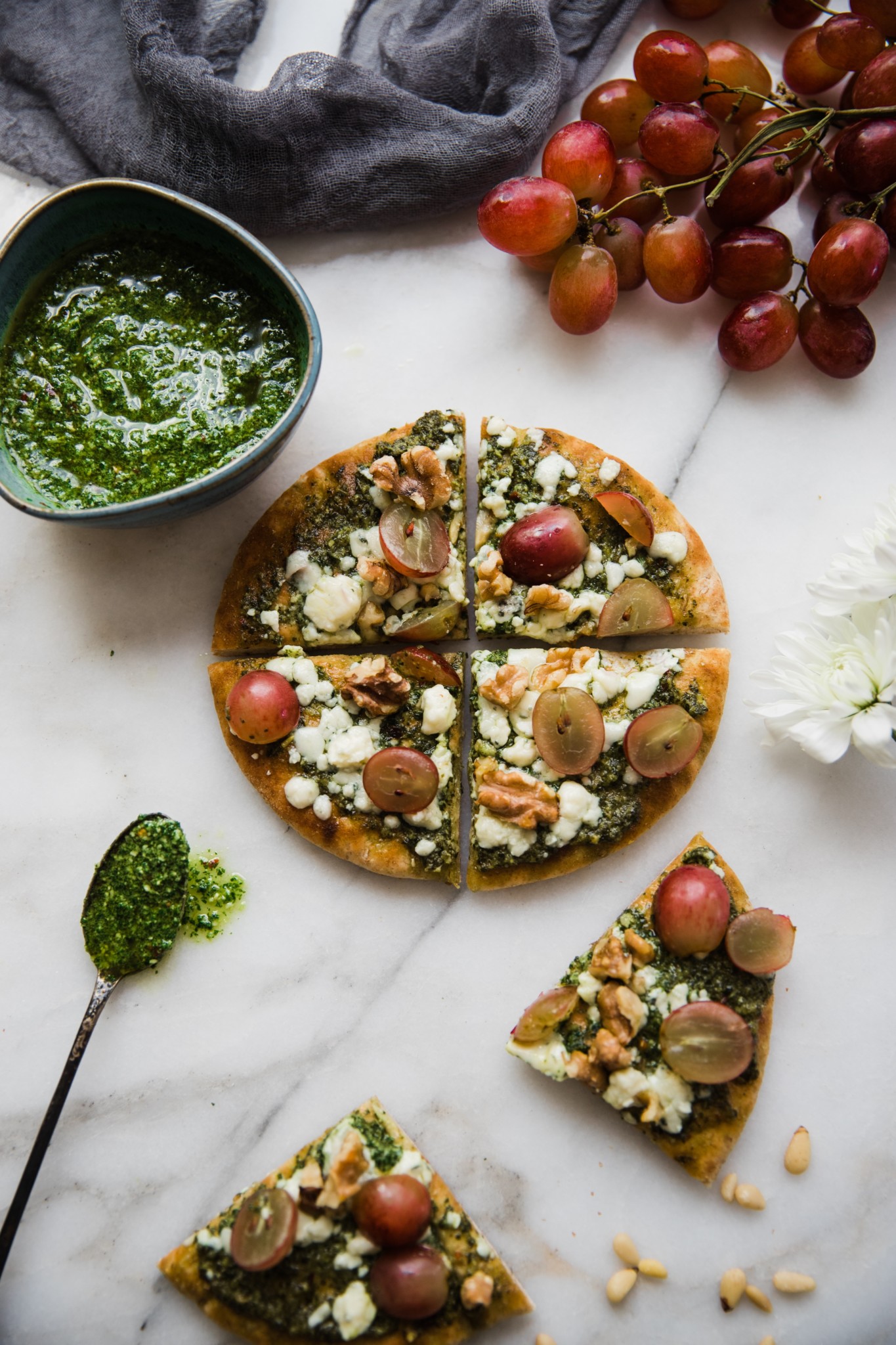 pita pizza made on pita bread with kale pesto, walnuts and red grapes