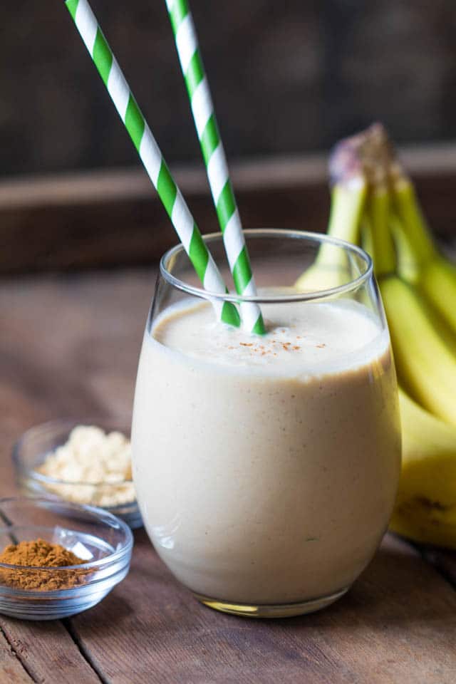 tan smoothie in a stemless wineglass with a green & white straw