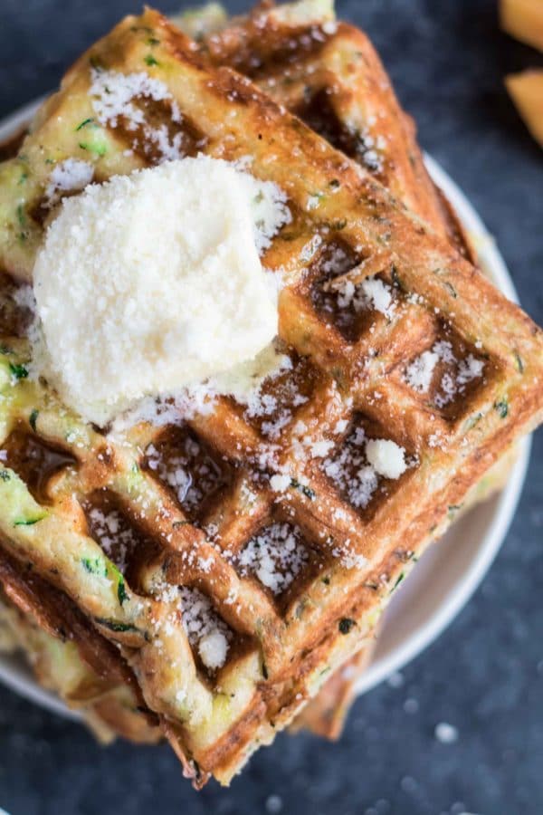 zucchini waffles on a plate topped with butter