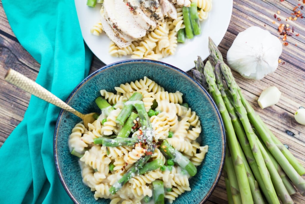 pasta in a blue bowl with chicken and asparagus