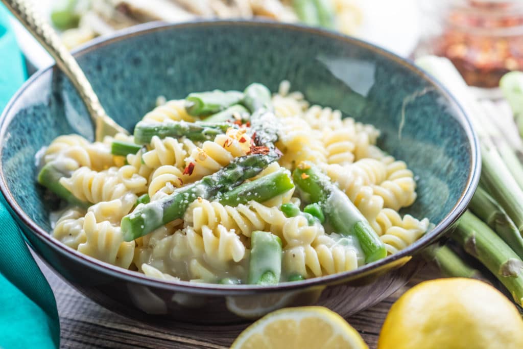 pasta in a blue bowl with chicken and asparagus