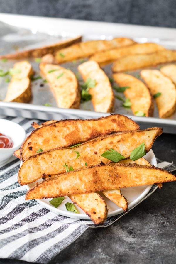 homemade potato wedges on white plate