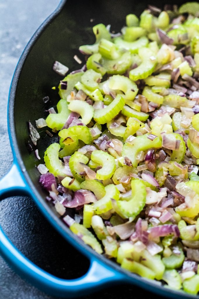 celery and red onions cooking in a skillet