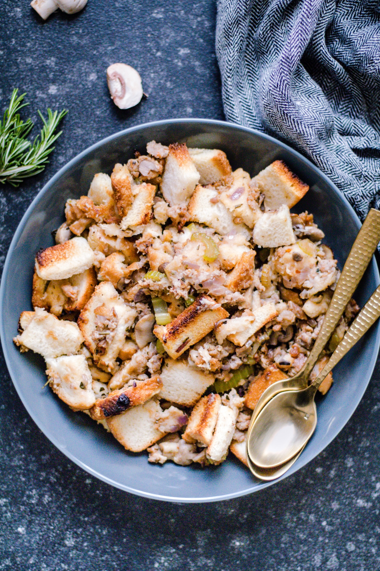 Thanksgiving stuffing in a bowl with gold spoons