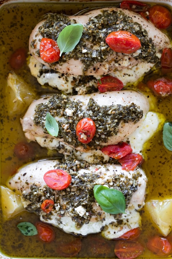 chicken topped with pesto in a baking dish