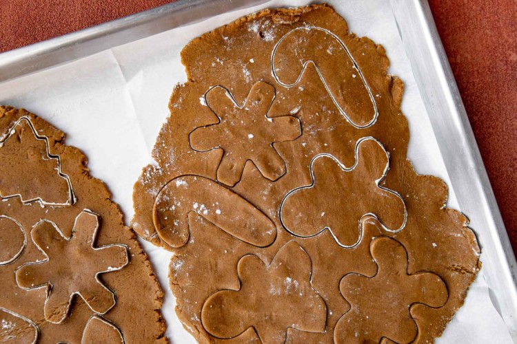 gingerbread cookie dough being cut into shapes