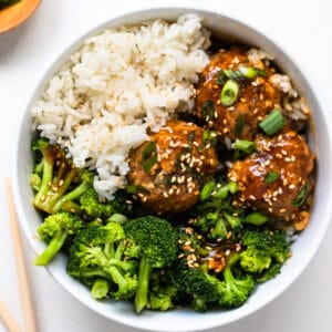 meatballs in a white bowl with broccoli and rice