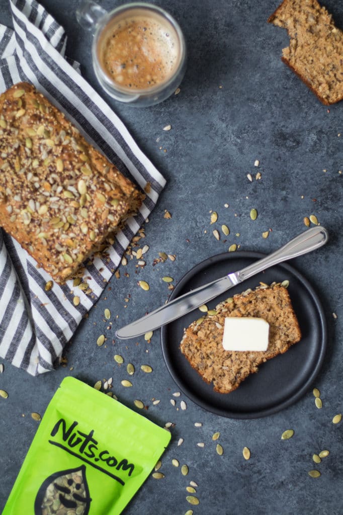 slice of sprouted bread on dark plate with butter knife