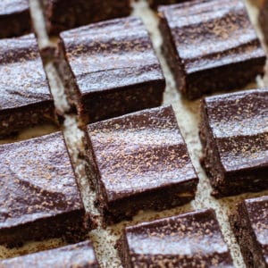 brownies on parchment paper dusted with cocoa powder