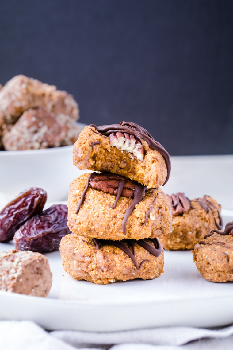 Pumpkin Cookies stacked on top of each other drizzled with dark chocolate.