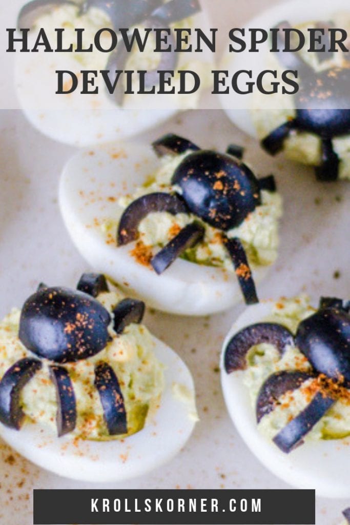 Deviled eggs made with avocado and Greek yogurt on a plate with olives shaped into spiders on top. A halloween appetizer!