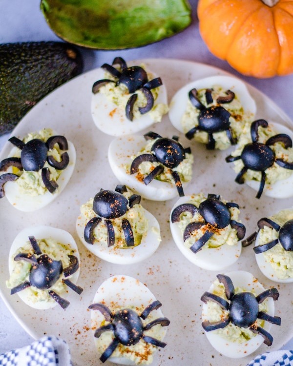 Halloween Deviled Eggs on a cream colored plate.