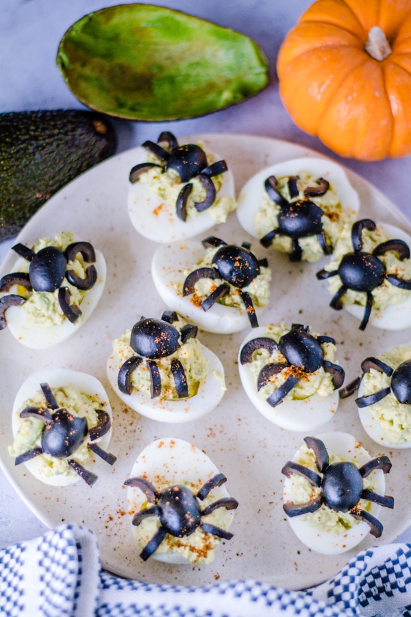 Halloween Deviled Eggs on a cream colored plate.