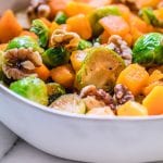 butternut squash and brussels sprouts in a bowl on a marble bowl.