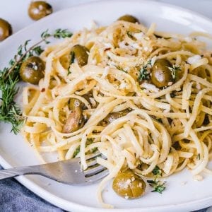 Herb Pasta Linguini on a plate mixed with fresh herbs and California Green Ripe Olives