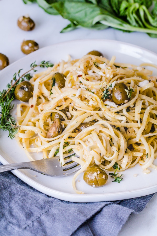 Herb Pasta Linguini on a plate mixed with fresh herbs and California Green Ripe Olives