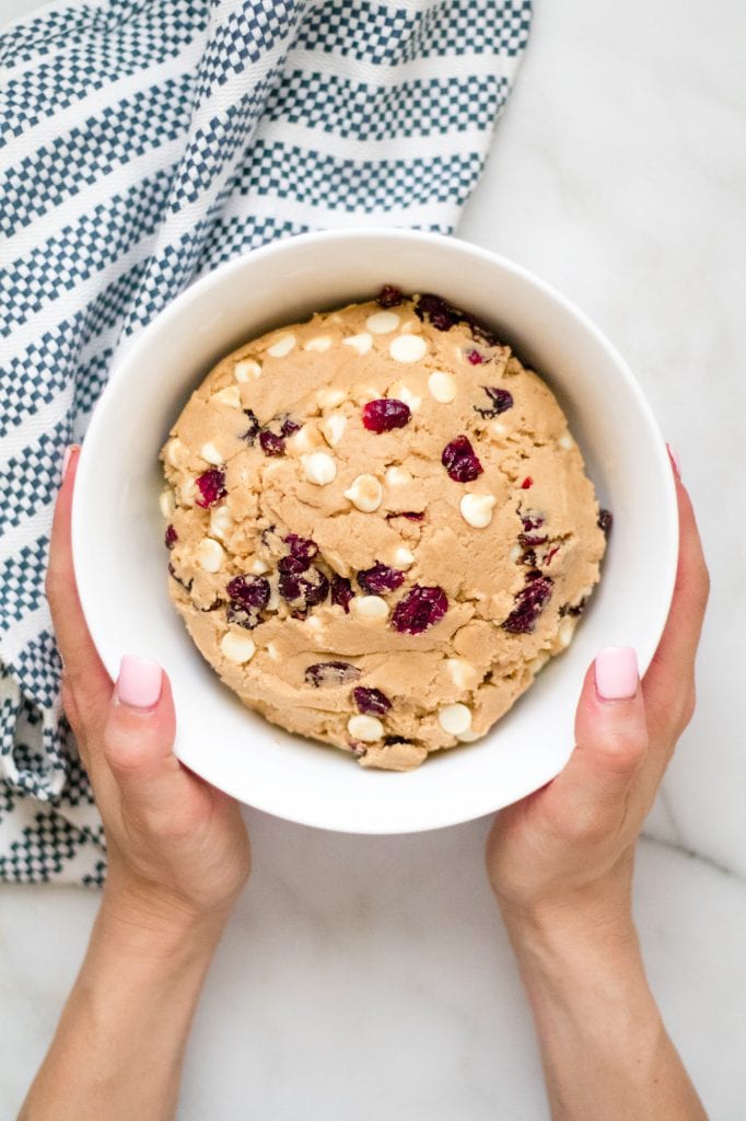 White chocolate cranberry cookie dough on a marble slab