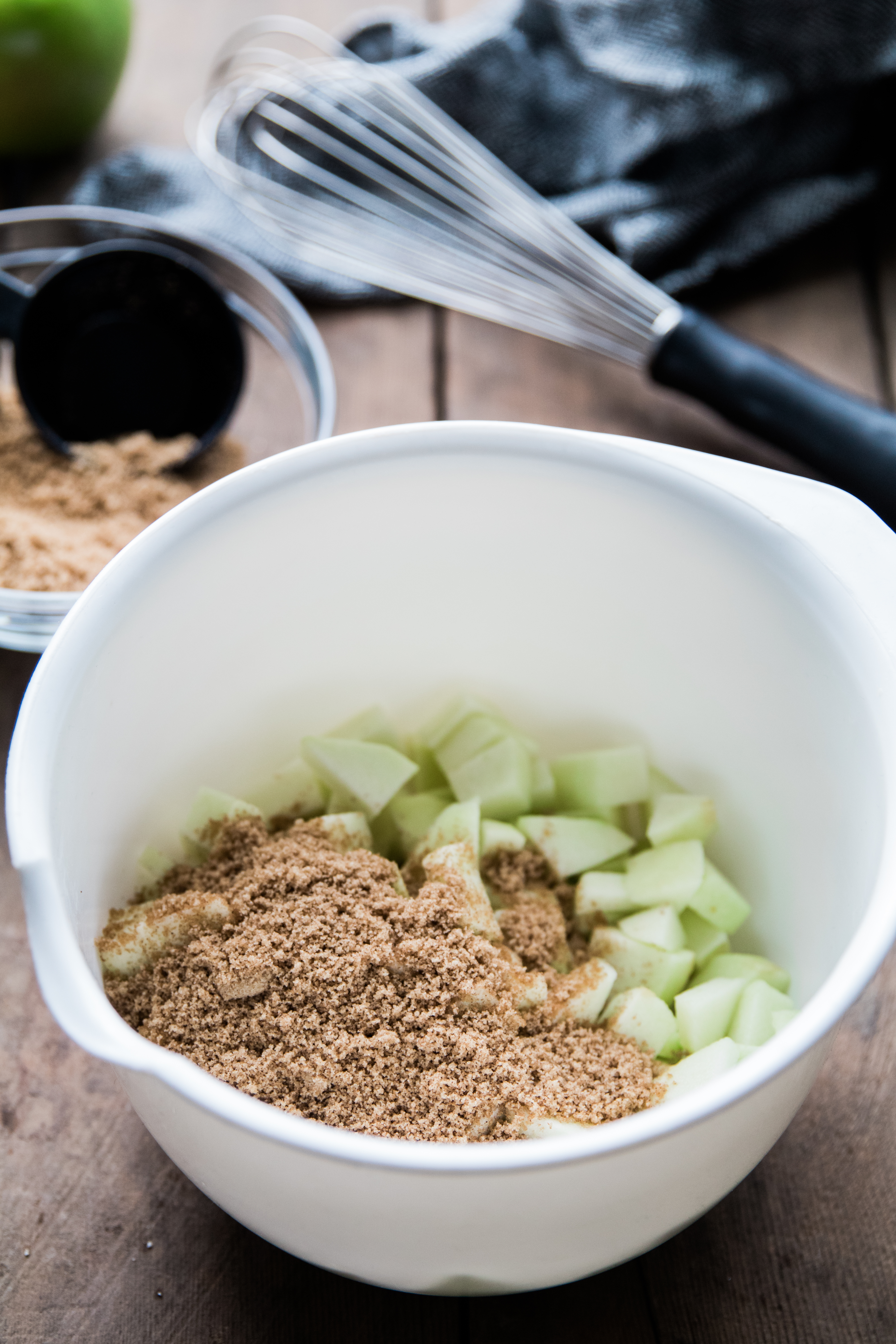 apples and cinnamon in a large white bowl