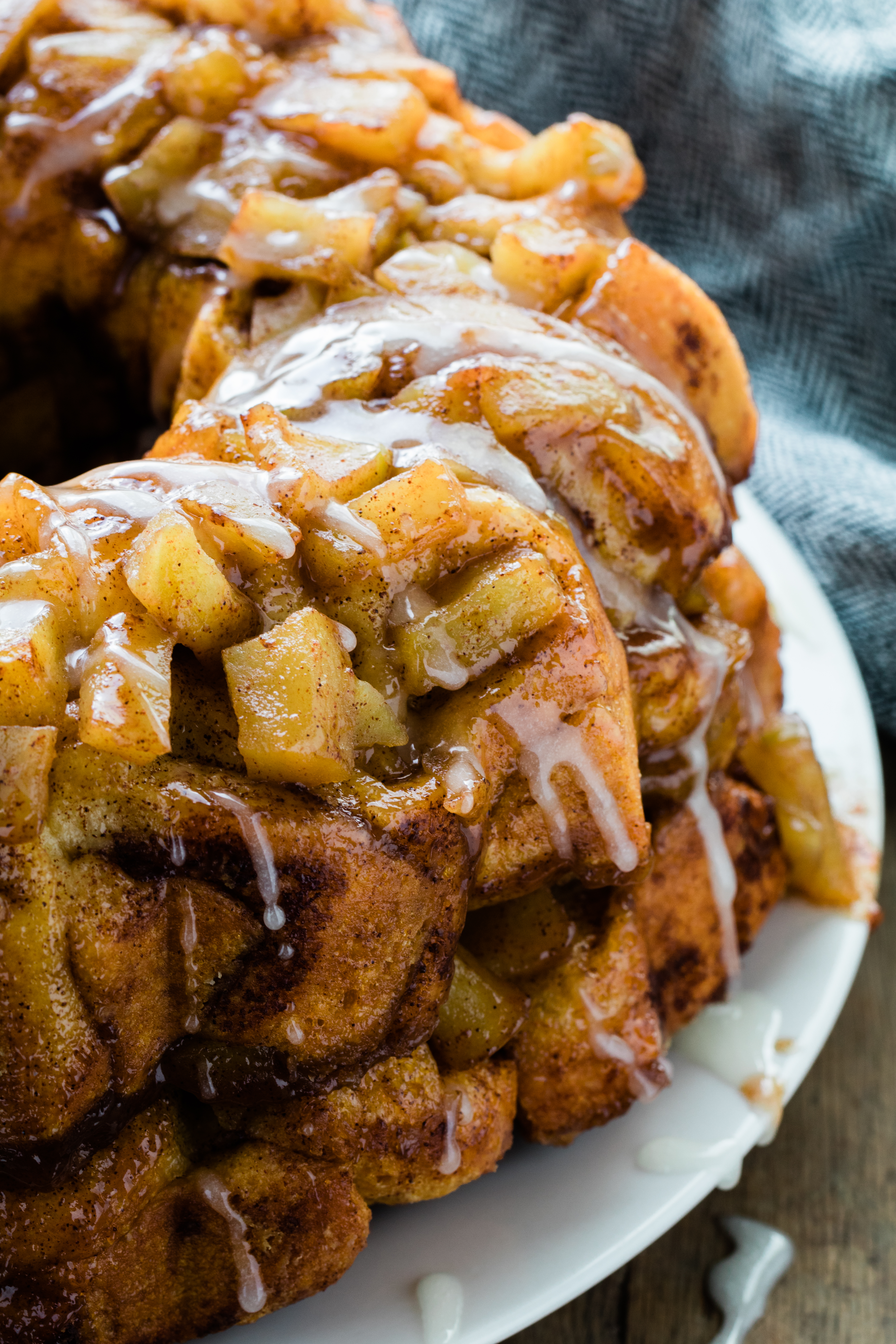 apple cinnamon monkey bread on a white plate with glaze