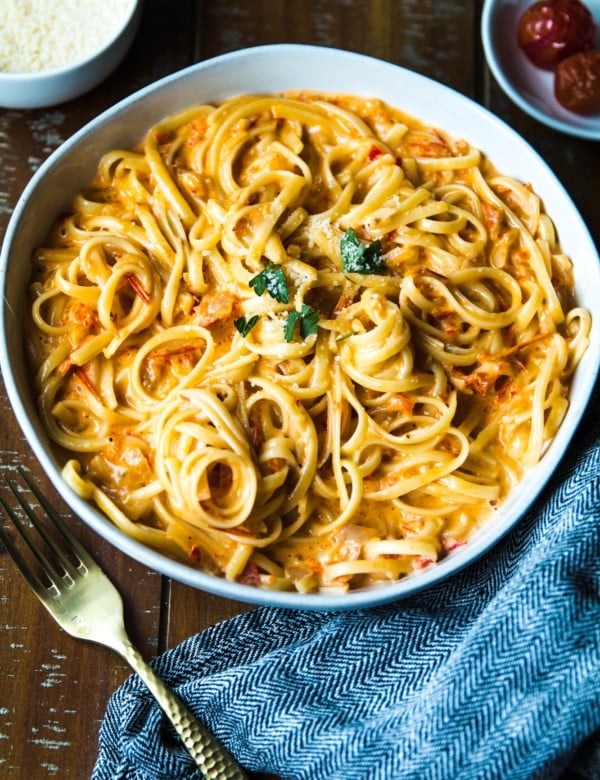 Pasta with tomatoes and bell peppers in a white bowl