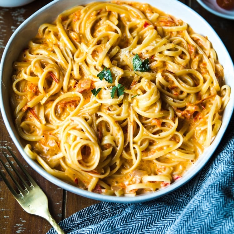 Pasta with tomatoes and bell peppers in a white bowl