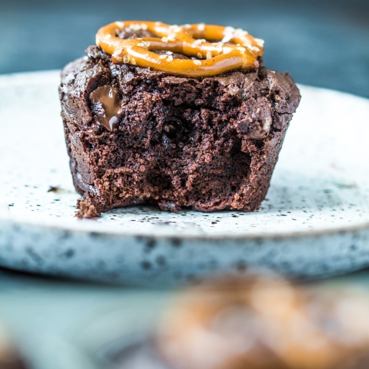 A brownie bite on a plate with melted chocolate