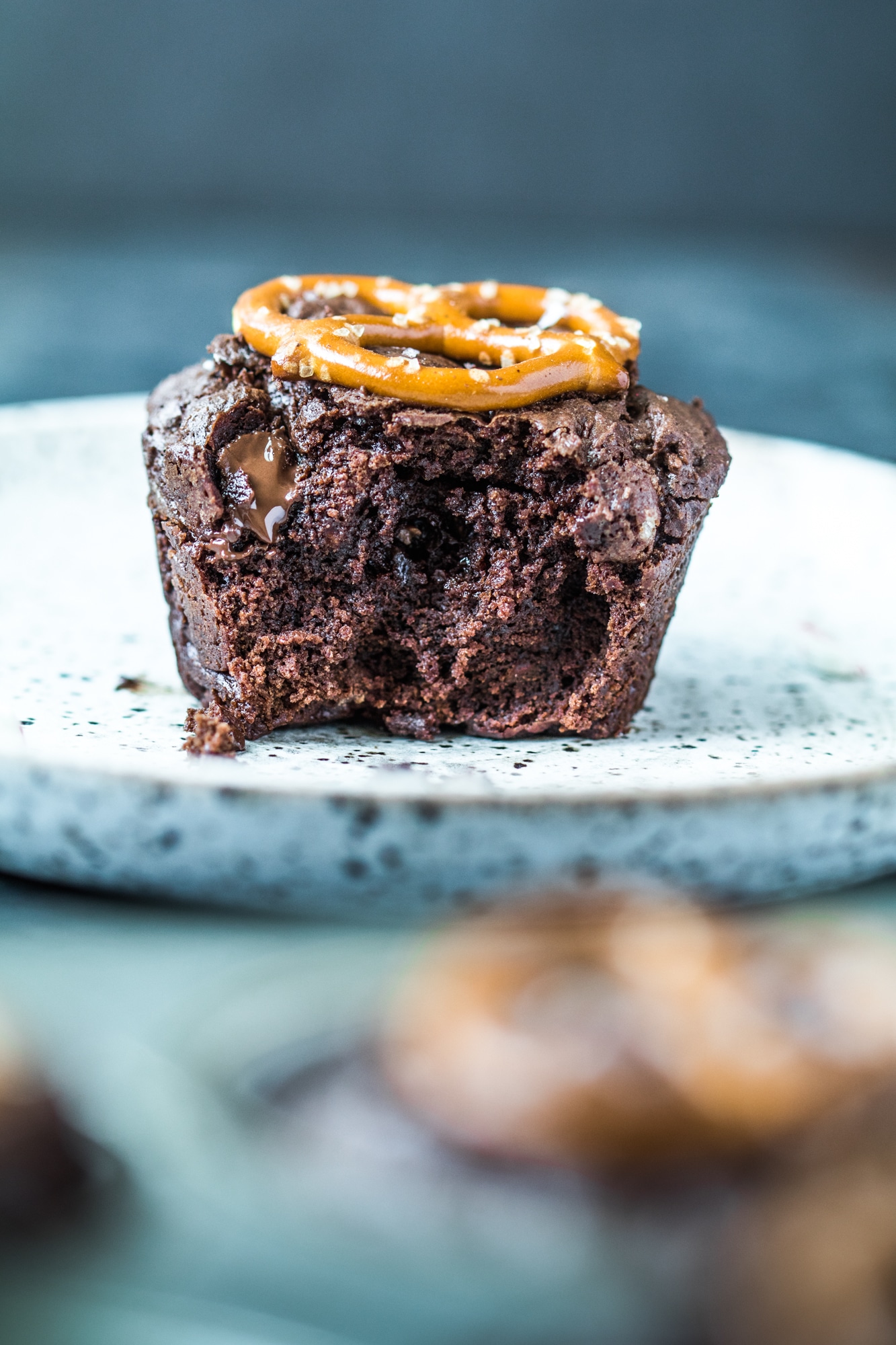 A brownie bite on a plate with melted chocolate