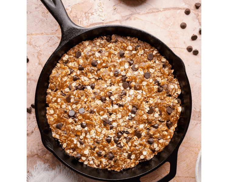 Dry ingredients, including flour, baking soda, baking powder, salt, and cinnamon, added to the wet batter in a large bowl before mixing.