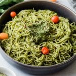 Pasta with pesto sauce in a bowl with cherry tomatoes