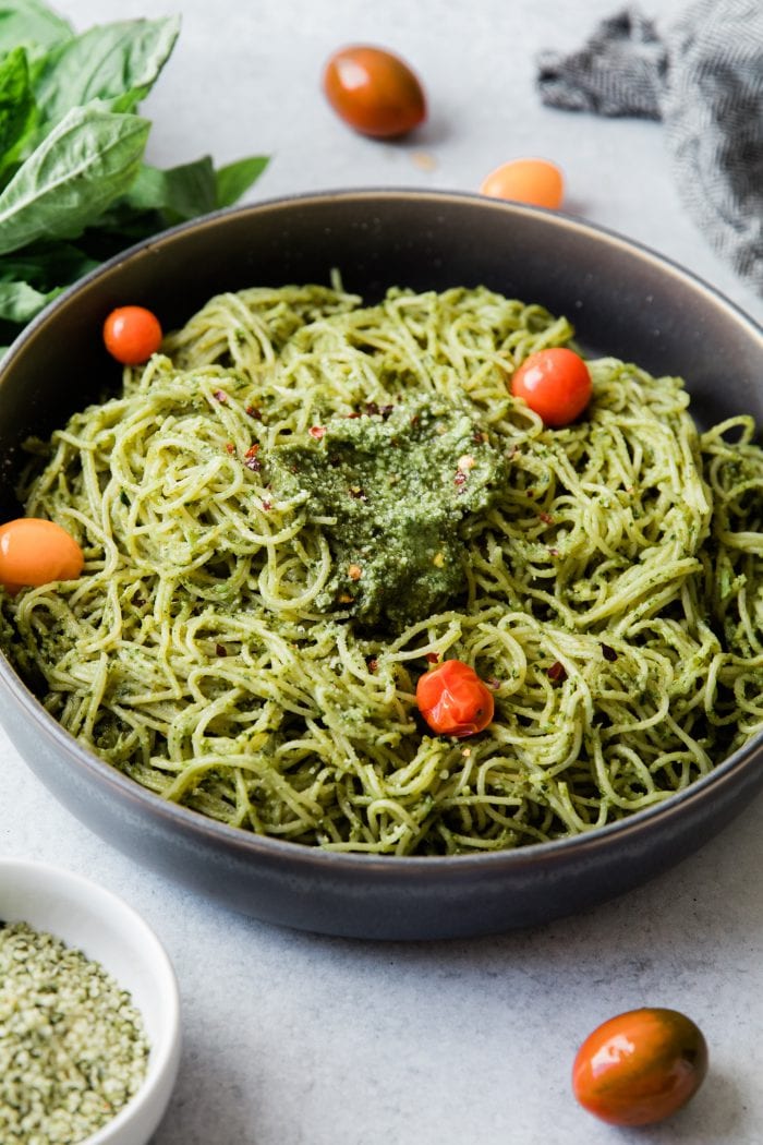 Pasta with pesto sauce in a bowl with cherry tomatoes