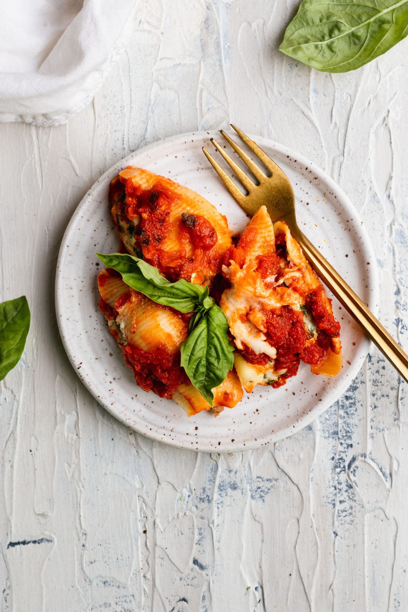 stuffed shells on a white speckled plate