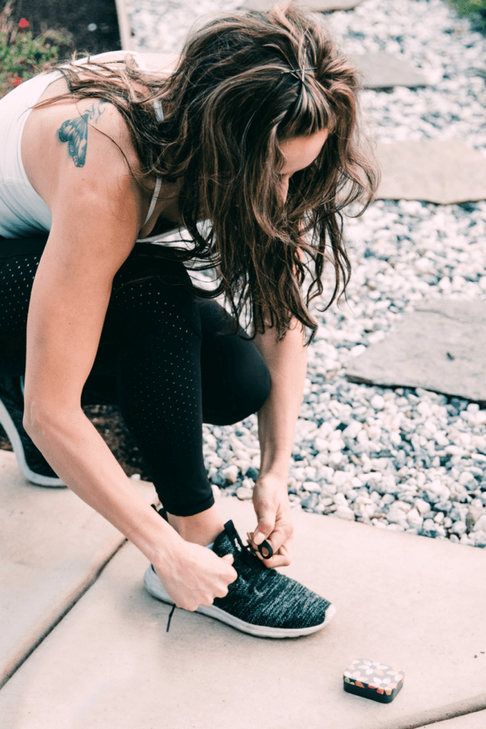 a woman tying her shoe