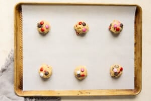 unbaked cookie dough balls on a baking sheet lined with parchment paper.