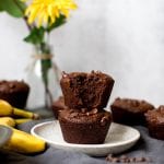 jumbo muffins on a white plate with flowers in a vase