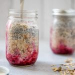 prepping overnight muesli in a mason jar with the fruit on the bottom