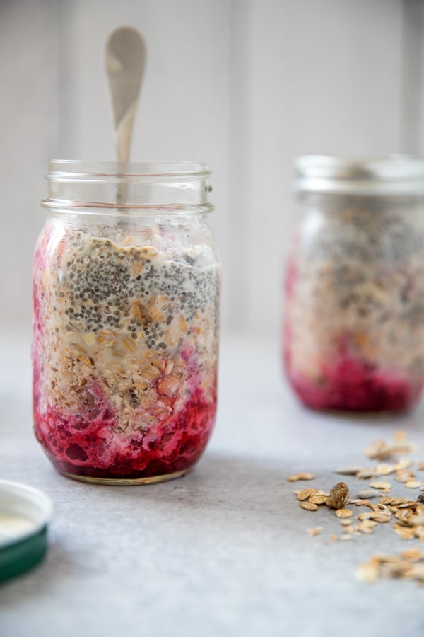 prepping overnight muesli in a mason jar with the fruit on the bottom