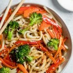 udon noodles tossed in sesame dressing in a white bowl