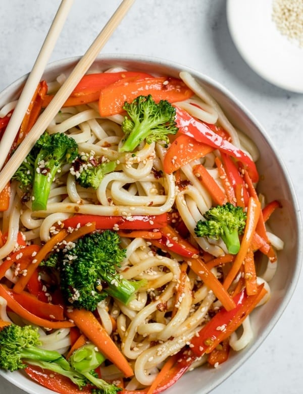 udon noodles tossed in sesame dressing in a white bowl