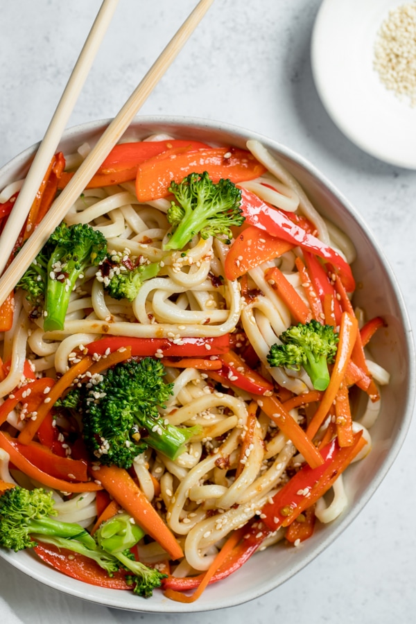 udon noodles tossed in sesame dressing in a white bowl