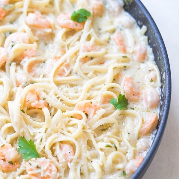 shrimp scampi in a large pan with parsley and parmesan cheese