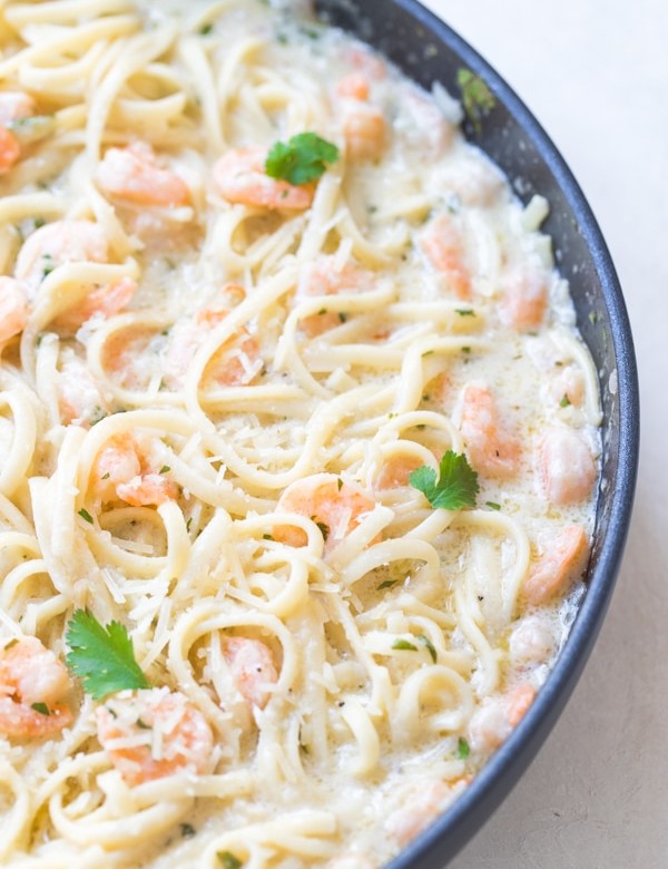 shrimp scampi in a large pan with parsley and parmesan cheese