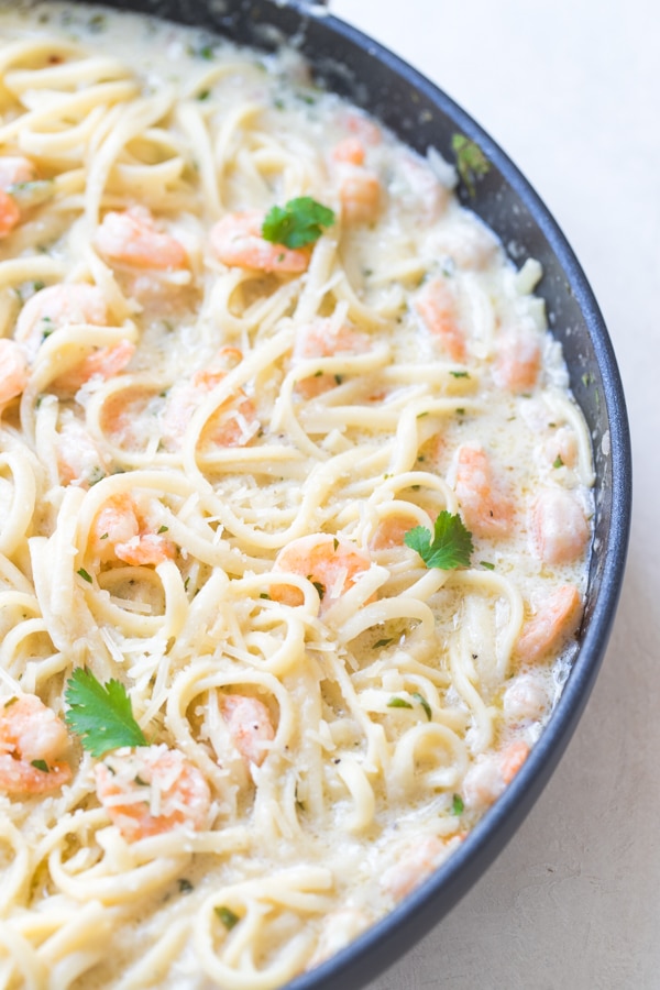 shrimp scampi in a large pan with parsley and parmesan cheese