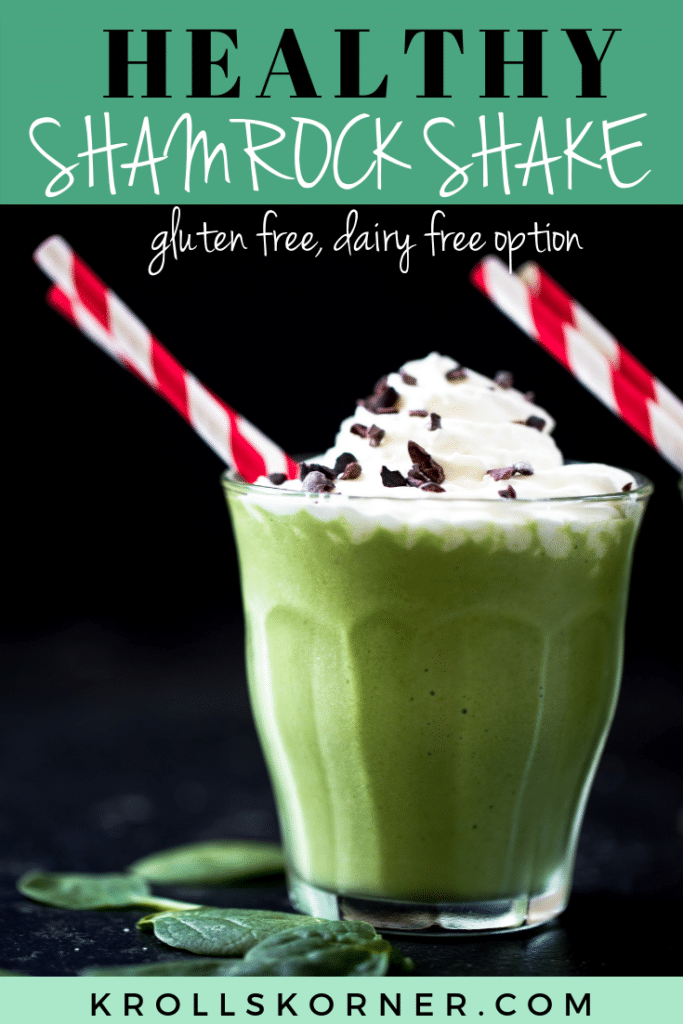 a green smoothie in a glass cup topped with whipped cream and red straws