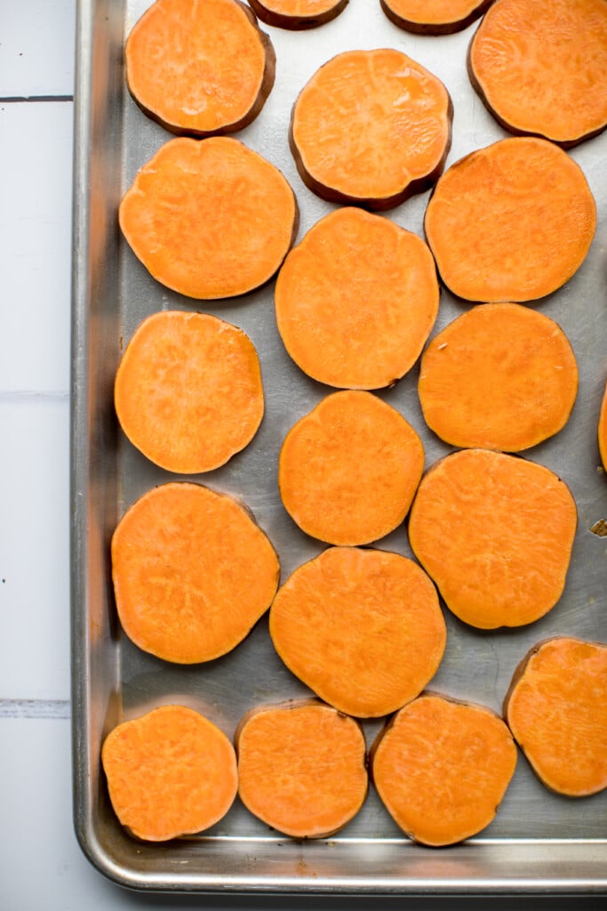 sliced sweet potato rounds on a baking sheet