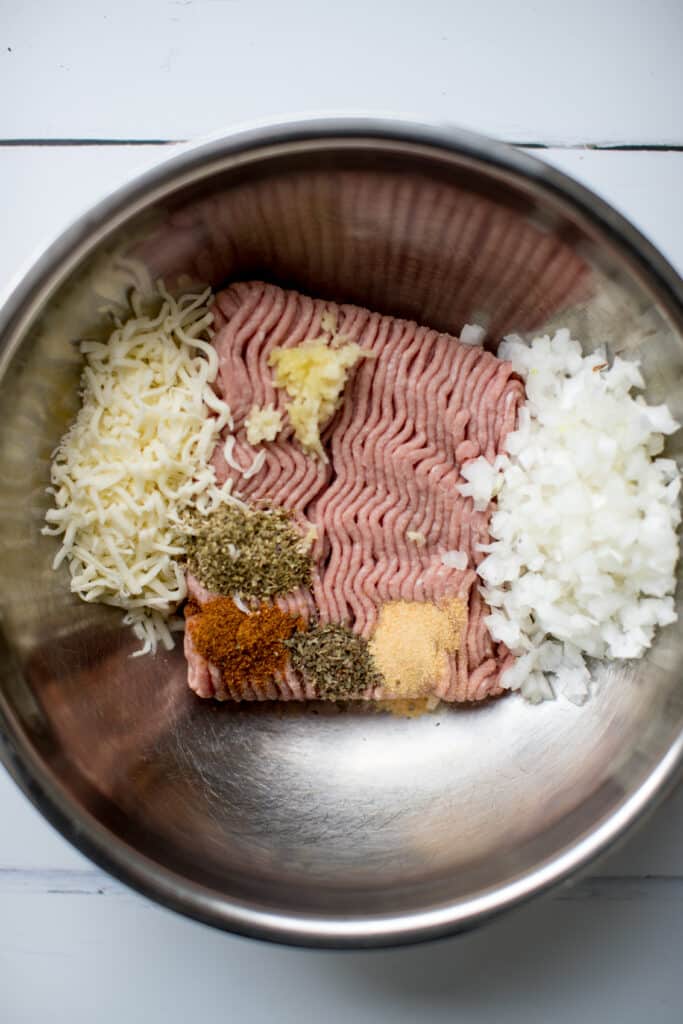 ground turkey in a stainless steel bowl with onion and seasonings 