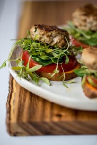 a turkey burger on a white plate with sweet potato