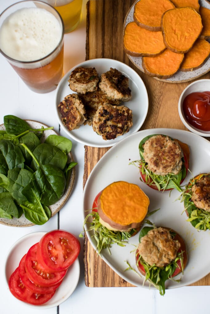 a turkey burger on a white plate with sweet potato