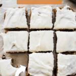 carrot cake bars on parchment paper with cream cheese frosting