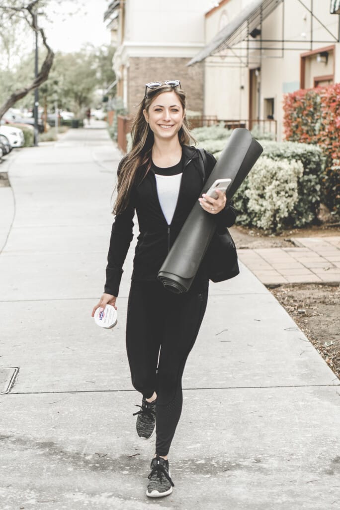 A woman walking down a sidewalk